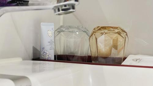 two glass containers sitting on a shelf in a refrigerator at Guangzhou Qiling LN DF Hotel in Huadu