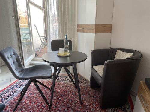 a room with a table and two chairs and a bottle of wine at Gästezimmer bei Ingrid in Tübingen
