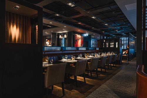 a long dining room with tables and chairs at Dakota Newcastle in Newcastle upon Tyne