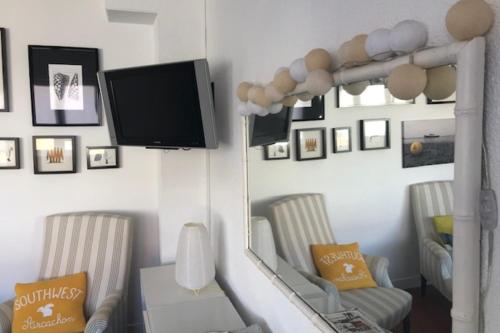 - un salon avec deux chaises et une télévision à écran plat dans l'établissement Apartment with balcony near the sea, à Arcachon