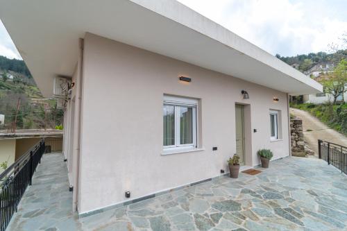a white house with a balcony with a window at Sylvia's Pramanta Villas in Pramanta