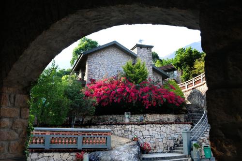 a stone building with pink flowers in front of it at Mountain Club Resort Munnar in Chinnakanal