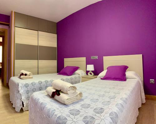 two beds in a room with purple walls at Apartamento Oteixon in Narvarte