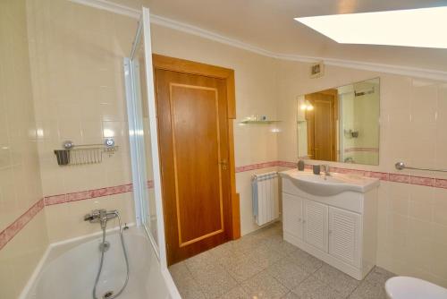 a bathroom with a tub and a sink and a toilet at 'Collasão' - Stunning Duplex with Pool & Sea Views in São Martinho do Porto