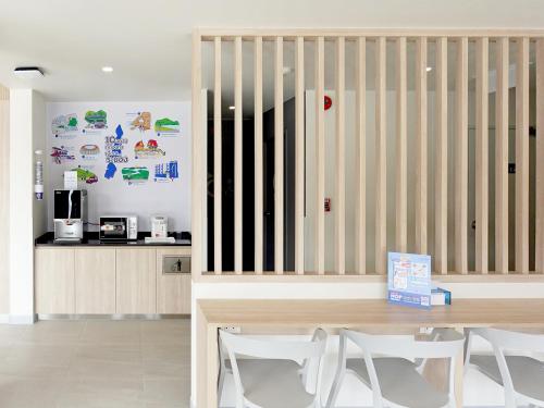 a dining room with a wooden table and white chairs at HOP INN Ranong in Ranong