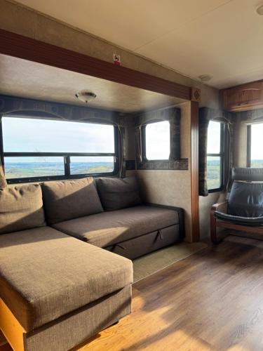 a couch and chair in a living room in a rv at 5th Wheel Trailer in Bere Alston
