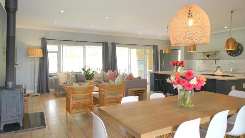 a kitchen and living room with a table with flowers on it at Saints Rest in Clarens