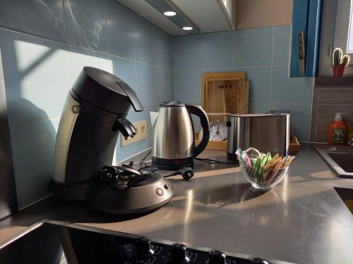 - un comptoir de cuisine avec une cafetière et une cuisinière dans l'établissement L'Ensoleillé - Spacieux - Central - Confortable, à Orléans