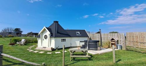 a small house in a yard next to a fence at Mawgies in Saint Ervan