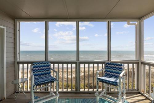 two chairs on a screened in porch looking out at the ocean at Breakers C32 condo in Pine Knoll Shores