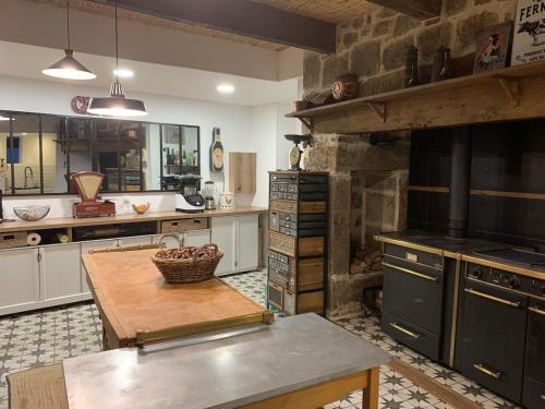 - une cuisine avec une table et un mur en pierre dans l'établissement Les sources d avenas, à Saint-Jean-Roure