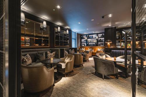 a bar with couches and tables and chairs at Dakota Newcastle in Newcastle upon Tyne
