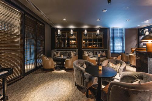 a bar with couches and tables and chairs at Dakota Newcastle in Newcastle upon Tyne