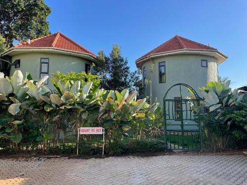 a house with a gate and a sign in front of it at Greenyard Beach Hotel in Nkumba