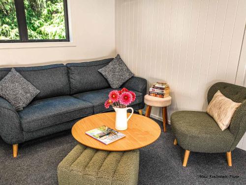 a living room with a couch and two chairs and a table at Pond Road Park - Raglan in Raglan