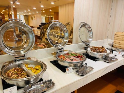 a buffet with many plates of food on a counter at Royal Seasons Hotel Taipei ‧ Nanjing W. in Taipei