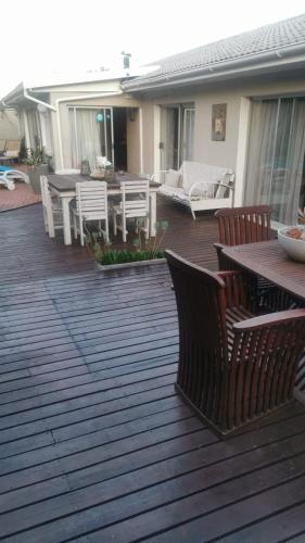 a wooden deck with a table and chairs on it at Walmer Heights Guest House in Port Elizabeth