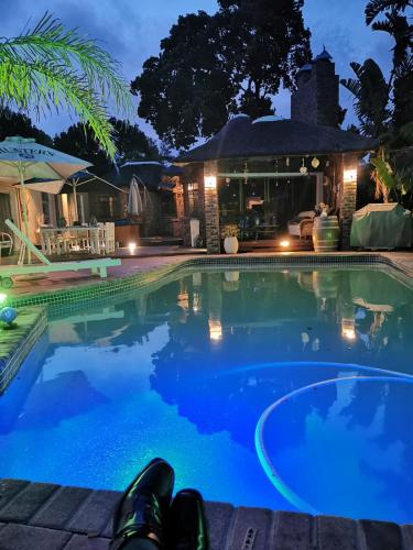 a swimming pool in front of a house at night at Walmer Heights Guest House in Port Elizabeth