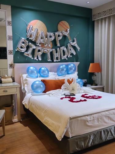 a bedroom with a bed with a sign that reads happy birthday at Sojourn Spa Hotel Melaka in Melaka