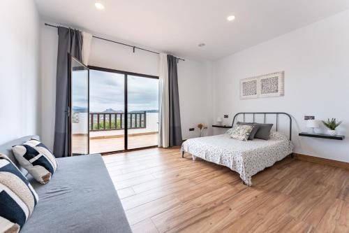 ein Schlafzimmer mit einem Bett und einem großen Fenster in der Unterkunft MalagaSuite Villa El Montecito in Antequera