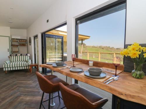 a dining room with a table with chairs and a large window at Llety Cariad in Llandrindod Wells