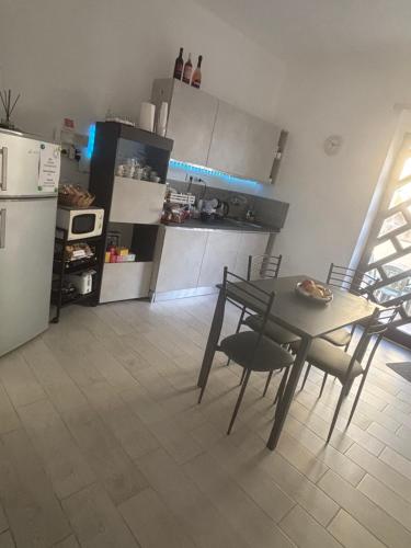 a kitchen with a table and chairs and a refrigerator at B&B Sole e Luna in Ponte Galeria