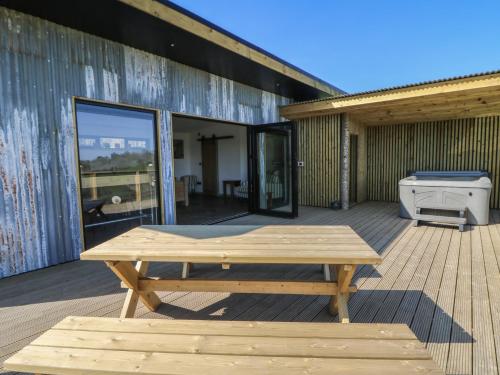 a picnic table on the deck of a building at Llety Cariad in Llandrindod Wells