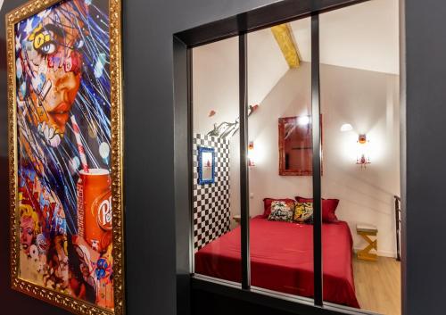 - une chambre avec un lit rouge et un grand miroir dans l'établissement Privatize 3 lofts 300 m2 & games bar by LOFT URBAN, à Saint-Étienne