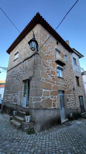 a stone building with two doors and a window at Casa de Unhais da Serra in Unhais da Serra