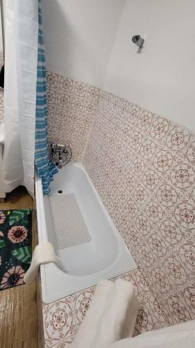 a white bath tub in a bathroom with tiles at Casa de Unhais da Serra in Unhais da Serra