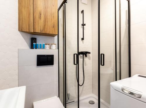 a bathroom with a shower and a toilet at Wejhera Beige Chic Apartment by BookingHost in Gdańsk