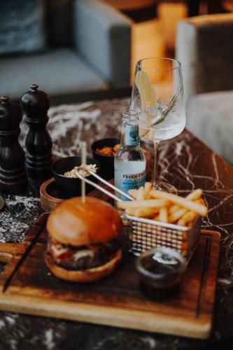 a tray with a hamburger and french fries and a glass of wine at Althoff Seehotel Überfahrt in Rottach-Egern