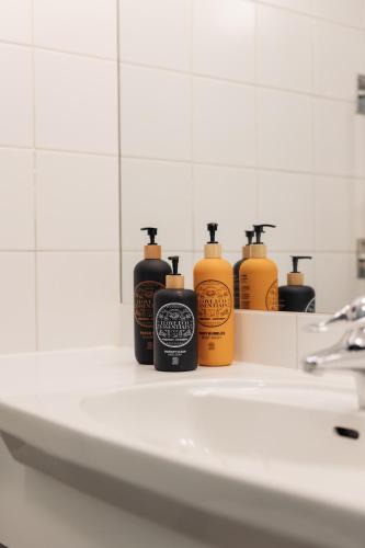four bottles of soap sitting on a bathroom sink at Botanika Uppsala in Uppsala