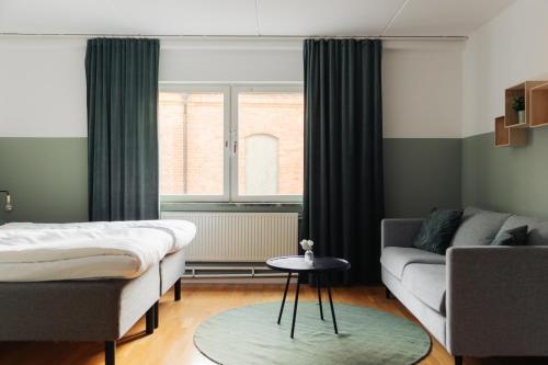 a living room with a couch and a window at Botanika Uppsala in Uppsala
