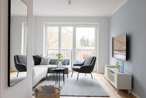 a living room with a couch and two chairs at Mole in Sankt Peter-Ording