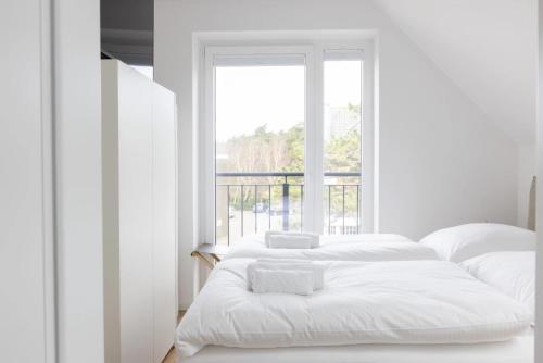 two beds in a white room with a window at Strand in Sankt Peter-Ording