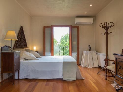 a bedroom with a large white bed and a window at Son Senyor in Sa Pobla