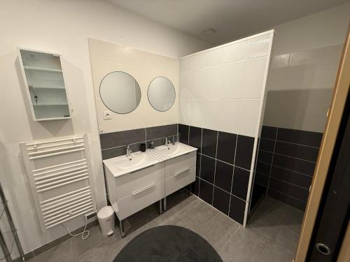 une salle de bain avec un lavabo et deux miroirs dans l'établissement Charmant appartement à Caromb Proche de toutes commodités, à Caromb