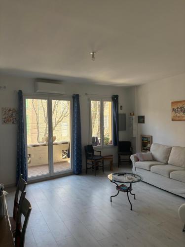 un salon avec un canapé et une table dans l'établissement Charmant appartement à Caromb Proche de toutes commodités, à Caromb