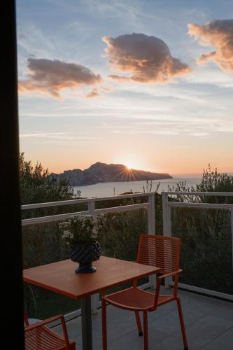a table and chairs on a balcony with the sunset at Villa Solaria in Massa Lubrense