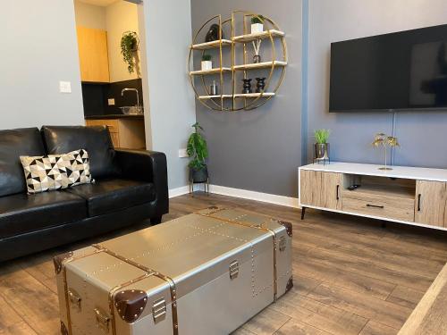 a living room with a couch and a tv at Pendle House - Apt 4 - 3 min walk to beach & Shops! in Colwyn Bay
