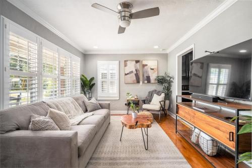 a living room with a couch and a flat screen tv at Charming 3BR Home Near DT with King Bed and Fire Pit in Orlando