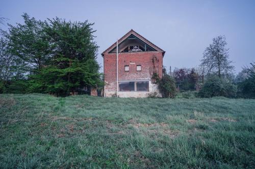 an old brick building on a grassy field at Land van Engelingen in Helshoven