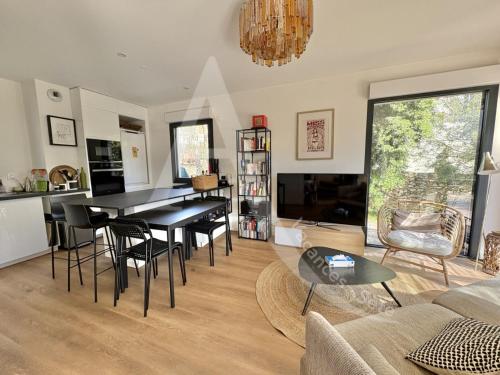 un salon avec une table et des chaises noires dans l'établissement Villa en bois moderne, tout comfort pour 6 personnes proche des plages, à Sète