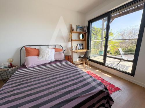 une chambre avec un lit et une grande fenêtre dans l'établissement Villa en bois moderne, tout comfort pour 6 personnes proche des plages, à Sète