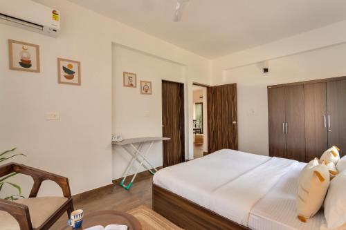 a bedroom with a large bed and a chair at 2bhk Bruno Nera Candolim 10 mins to beach in Nerul