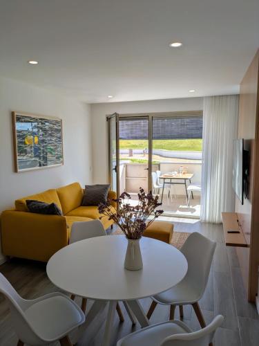 a living room with a white table and chairs at Porta da Praia - Paredes da Vitória in Senhora da Vitória