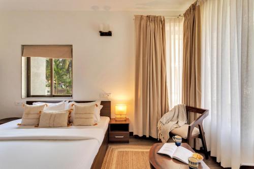 a hotel room with two beds and a chair at 2bhk Bruno Nera Candolim 10 mins to beach in Nerul