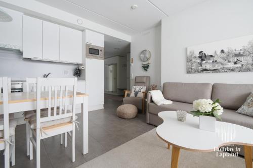 a living room and kitchen with a couch and a table at Holiday In Lapland - Ylläs Sivulantie 4 214 in Äkäslompolo