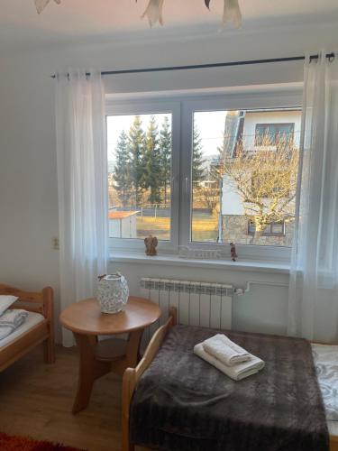 Zubrzyca GórnaにあるWolna chataのベッドとテーブルと窓のある寝室